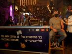 A health worker administers the COVID-19 vaccine to an Israeli at a bar in the coastal city of Tel Aviv on February 18, 2021. (Photo by GIL COHEN-MAGEN / AFP)