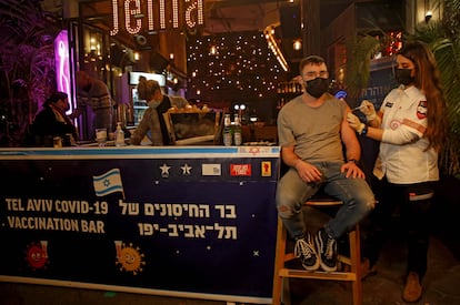 Una sanitaria administra una vacuna contra la covid en un bar de Tel Aviv.