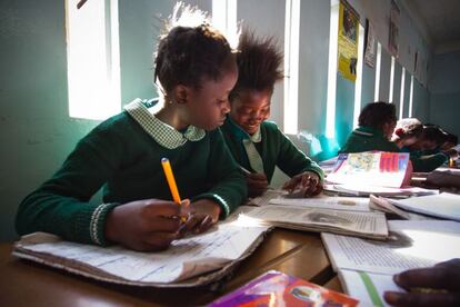 Zambia, 2012. Niñas huérfanas (generalmente debido al VIH/SIDA) y vulnerables, reciben enseñanza en la Mary Aikenhead Open Community School. Estuvo visitando la escuela junto con un grupo de periodistas. Mientras ellos entrevistaban a algunos alumnos, Abarca se dio un paseo por las clases. Muchos niños se distraían con la cámara, pero al fotógrafo le llamó la atención como estas dos continuaron con sus tareas, ayudándose la una a la otra.