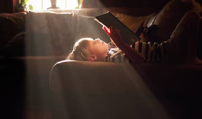 Un niño lee sobre su cama.