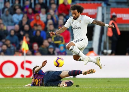 Marcelo, en posesión del balón, salta sobre Iván Rakitic.