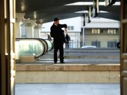 Un viajero comprueba la hora en su reloj de muñeca mientars espera en un andén de la estación de trenes de Canpanha en Oporto (Portugal). EFE/Archivo
