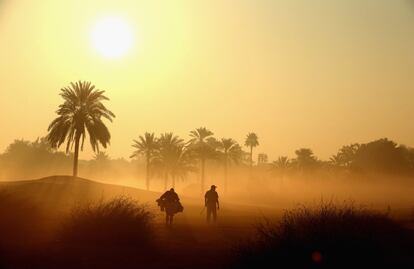 Un golfista y su cadie caminan cerca del hoyo 10 durante el torneo Pro-Am Omega Dubai Desert Classic en el Emirates Golf Club de Dubai, Emiratos Árabes 