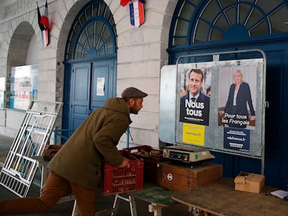 Un hombre coloca cajas de verduras delante de carteles electorales, este sábado en el mercado de Salies de Bearn, en el suroeste de Francia.