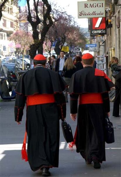 Dos cardenales caminan por una calle de  Roma en dirección al Vaticano.