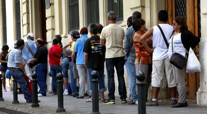 Una hilera de personas espera que abra el comedor de Casa Caridad en Valencia.