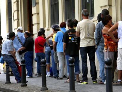 Una hilera de personas espera que abra el comedor de Casa Caridad en Valencia.