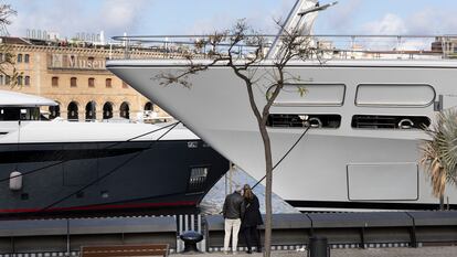 Dos turistas observan los yates en el Port Vell.