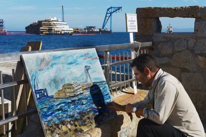 Un hombre pinta los trabajos de reflotamiento del buque Costa concordia en Gilio. 