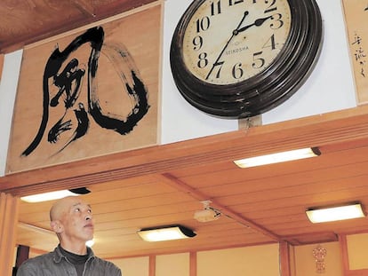 Sakano contempla el reloj de pared que ha vuelto a funcionar en su monasterio.