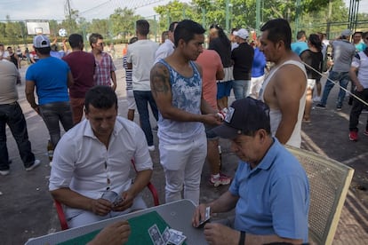 Ambiente alrededor de la cancha del Parque de las Cuña Verde de Latina, en el barrio Lucero donde se organizan partidas de cartas y otros juegos de mesa. Fuera del campo se mueve mucho más dinero en apuestas que dentro de él. Se trata de un entretenimiento para quienes pasan las tardes en jornadas de ecuavoley.