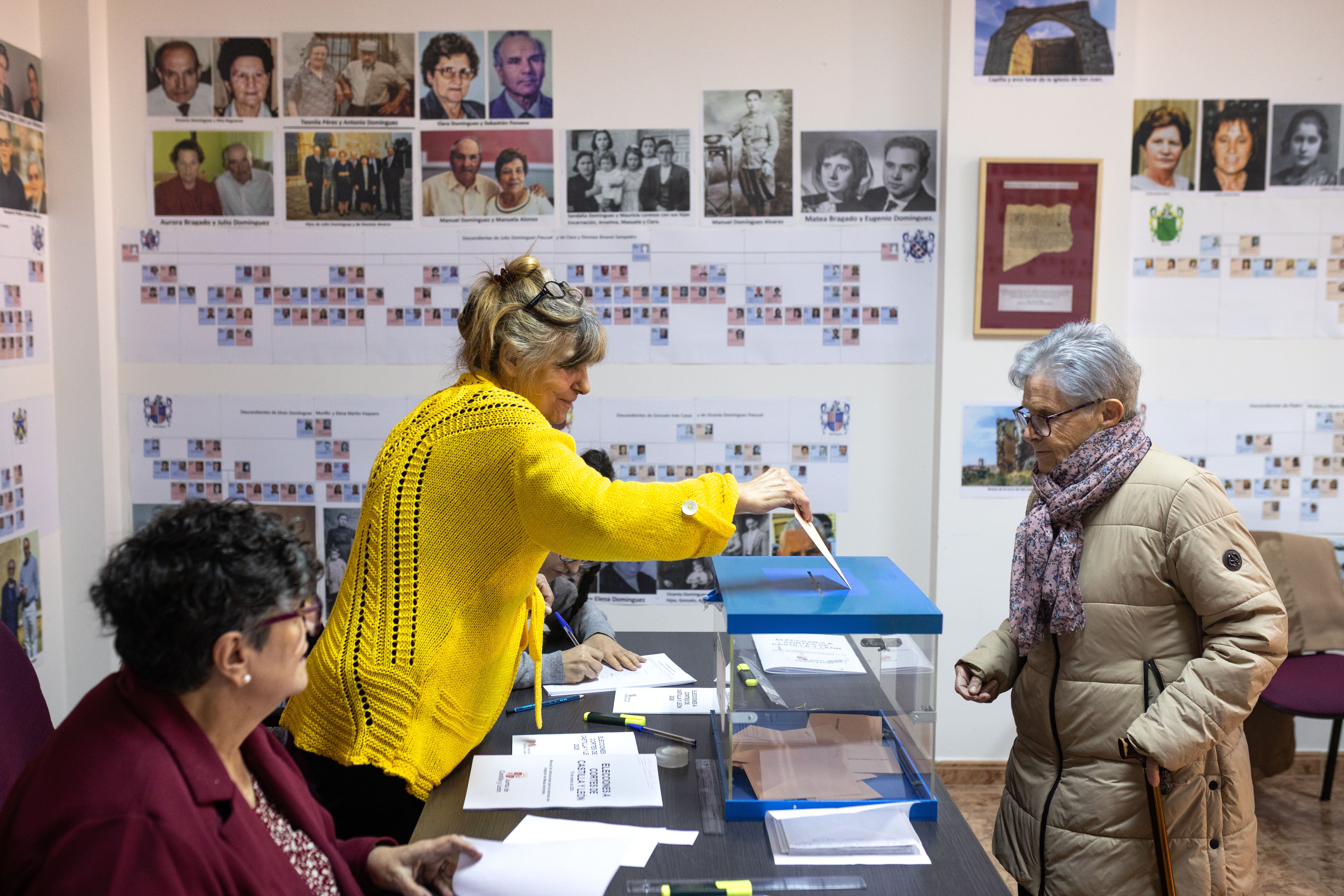 Una mujer vota en el colegio electoral de Malva (Zamora), adornado con los árboles genealógicos del pueblo.