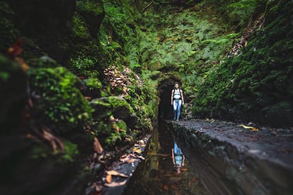 Una mujer caminando por la 'levada' do Caldeirão Verde (PR9).