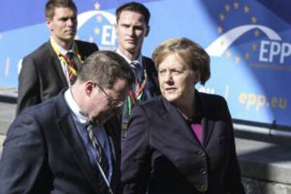 La canciller alemana, Angela Merkel (dcha), a su llegada a la reunión del Partido Popular Europeo antes del inicio de la cumbre de jefes de Estado y Gobierno de la Unión Europea (UE), en Bruselas.