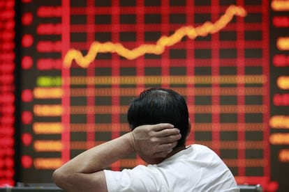 El yuan se ha apreciado un 2% hasta junio frente al dólar. En la imagen, un inversor observa los índices de la bolsa de Shanghai.