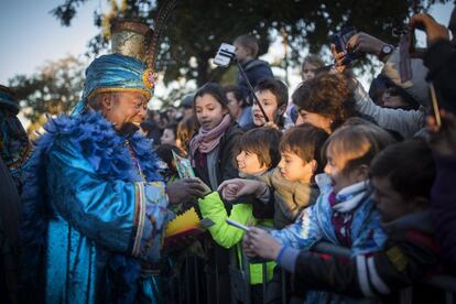 El rey Baltasar recoge cartas de los niños que esperaban a los Reyes Magos de Oriente, quienes han llegado esta tarde por mar al Moll de la Fusta de Barcelona.