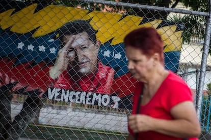 A woman walks past an image of Hugo Chávez, who hasn't been seen in public for nearly a month.