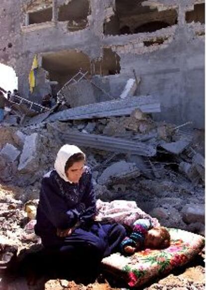 Una mujer palestina y su hija, ayer junto a su casa destruida en Gaza.