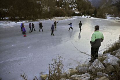 Un grupo de niños juegan en el Río Esca en Navarra, que permanece congelado por las bajas temperaturas