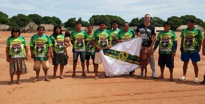 Miembros de la tribu Xingú con la bandera de la escuela de samba Emperatriz Leopoldinense