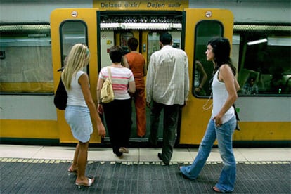 Varias personas suben al metro a primeras horas de la mañana en la reabierta estación de Jesús de la línea 1 de Valencia.