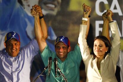 Presidential candidate Henrique Capriles raises his hands with Zulia state governor Pedro Pérez and independent candidate María Corina Machado in Caracas on Sunday.