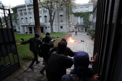 Un grupo de encapuchados ataca la embajada de Argentina durante una manifestación para protestar por la muerte del activista argentino Santiago Maldonado en Santiago (Chile).