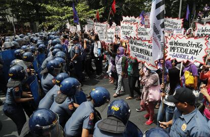 A polícia bloqueia a passagem das manifestantes que participam em uma marcha pelo Dia da Mulher, em Manila (Filipinas).