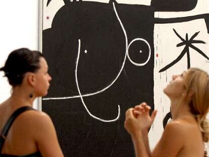 Dos visitantes ante <i>Mujer delante de la luna II</i> (1974), una de las obras de la exposición.