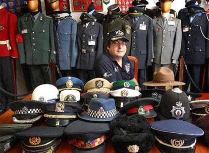 David Rodríguez, rodeado de su colección de uniformes, gorras y placas de policía de todo el mundo.