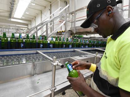 Un hombre pega una etiqueta de cerveza en una f&aacute;brica de Abidjan (Costa de Marfil).