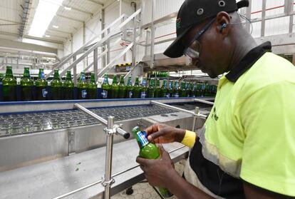 Un hombre pega una etiqueta de cerveza en una fábrica de Abidjan (Costa de Marfil).