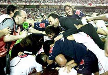 Caparrós, técnico del Sevilla, forma una montaña humana con sus jugadores tras el pitido final.