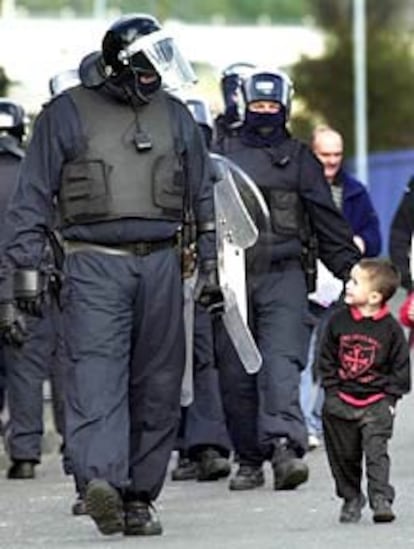 Un niño católico, camino de su colegio, charla con un policía antidisturbios en una zona protestante de Belfast.