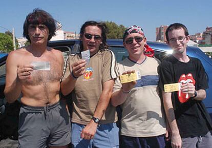 Seguidores de los Stones, ayer en Benidorm, con la entrada del concierto suspendido en la mano.