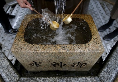 Visitantes del tempo de Daikyoji (Tokio), recogen agua con sus cazos en un manantial de agua natural conocido como el "agua divina". Los habitantes del lugar beben el agua o se lavan las manos con ella para purificarse y atraer a la buena fortuna.