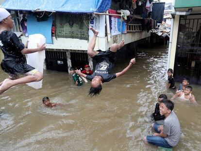 Varios niños juegan a tirarse al agua en una calle inundada de Yakarta, capital de Indonesia, el 25 de febrero.