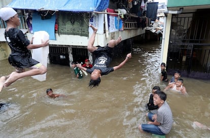 Varios niños juegan a tirarse al agua en una calle inundada de Yakarta, capital de Indonesia, el 25 de febrero.