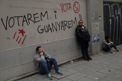 Un grupo de gente espera en el exterior de un centro electoral de Barcelona.