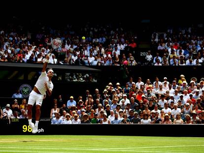 Federer sirve durante un partido en la pista central de Wimbledon.