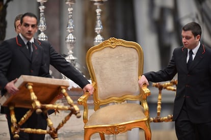 Empleados del Vaticano trasladan la silla del Cardenal italiano Angelo Sodano antes de la misa 'Pro eligendo Pontifice' en la Basílica de San Pedro.