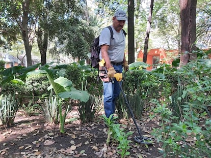 Joaquín Morales busca monedas en el Parque México de la capital.