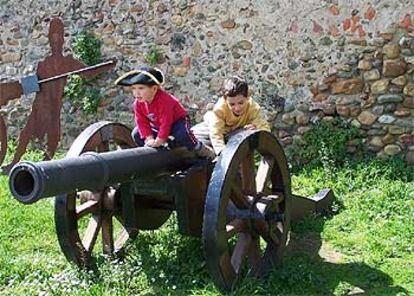 Dos niños juegan subidos a un cañón en el paseo de las Guarniciones, en Ciudad Rodrigo (Salamanca).