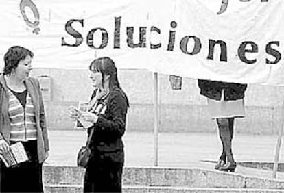 Dos mujeres ante una pancarta en la manifestación de ayer en Bilbao.