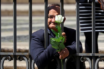 Antonino Siracusa, un ex sin hogar y ahora voluntario de San Egidio, sostiene una rosa blanca mientras espera la llegada de la comitiva fúnebre papal a Santa María la Mayor. 