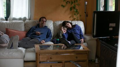 Una familia viendo la televisión en el salón de su casa.