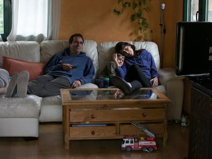 Una familia viendo la televisión en el salón de su casa.