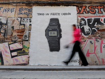 Una persona pasa ante un grafiti del artista callejero J. Warx, que alude al reloj mencionado en 'Session 53', este lunes en Valencia (España).