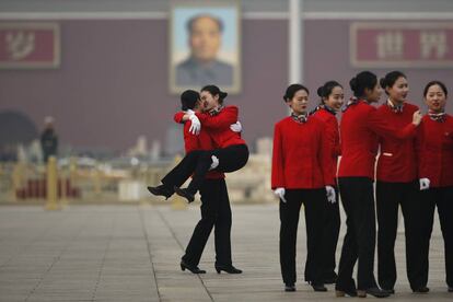 Azafatas se divierten mientras toman fotos de recuerdo en la Plaza Tiananmen, durante una sesión plenaria de la Conferencia Consultiva Política del Pueblo Chino (CCPPCh) en el Gran Palacio del Pueblo en Pekín.