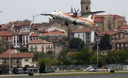 Un avión de Iberia despega del aeropuerto de Hondarribia con el casco urbano de esta localidad al fondo.